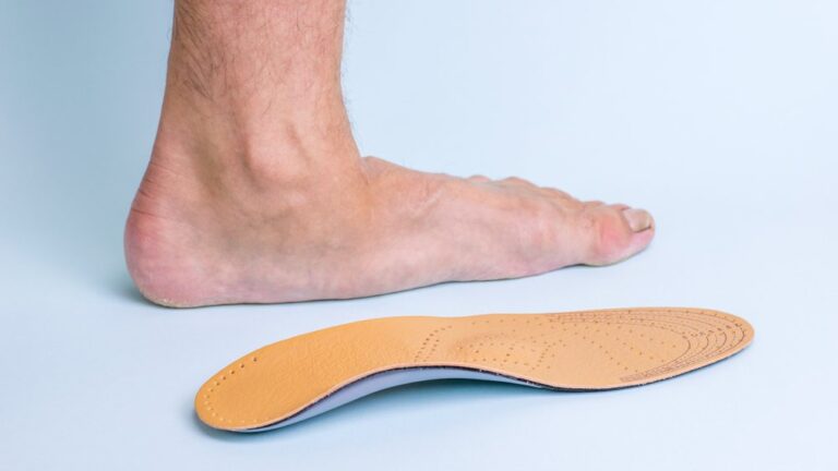 Side view of a flat foot next to an orthotic insole for arch support on a light background